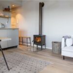 Jotul F100 ECO 2 Wood Burning Stove With Long Legs and Tracery Door installed on a flat wall
